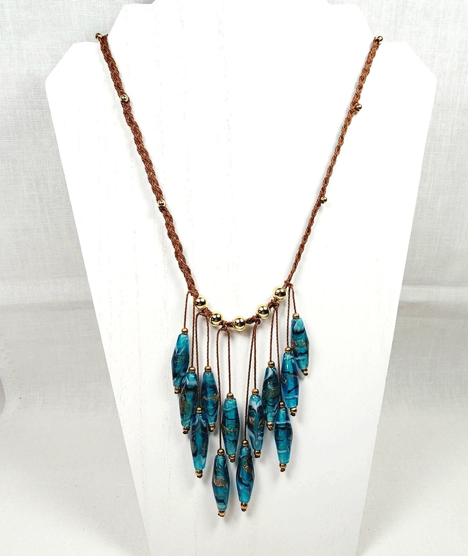 Teal Glass Boho Necklace โ Handmade Jewelry with Rhombus Lampwork Beads, Golden Accents & Adjustable Braided Brown Cotton Cord