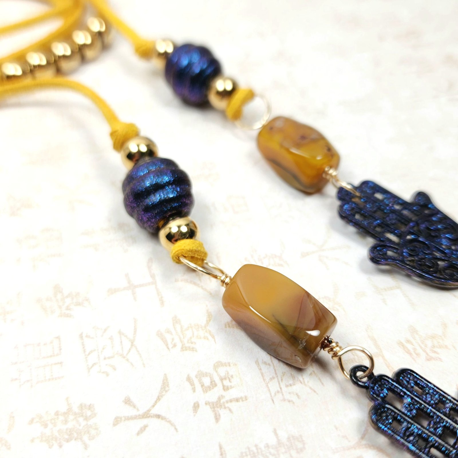 Boho Hamsa Hand Necklace โ Handmade Jewelry with Blue Hamsa Charm, Yellow Jasper, Golden Beads & Tassel on Faux Suede Brown Cord - Image 3