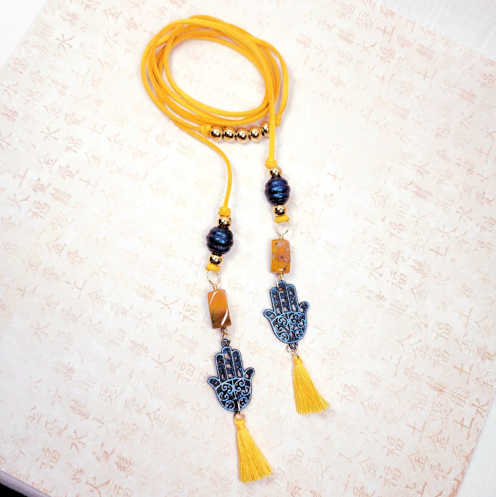 Boho Hamsa Hand Necklace โ Handmade Jewelry with Blue Hamsa Charm, Yellow Jasper, Golden Beads & Tassel on Faux Suede Brown Cord